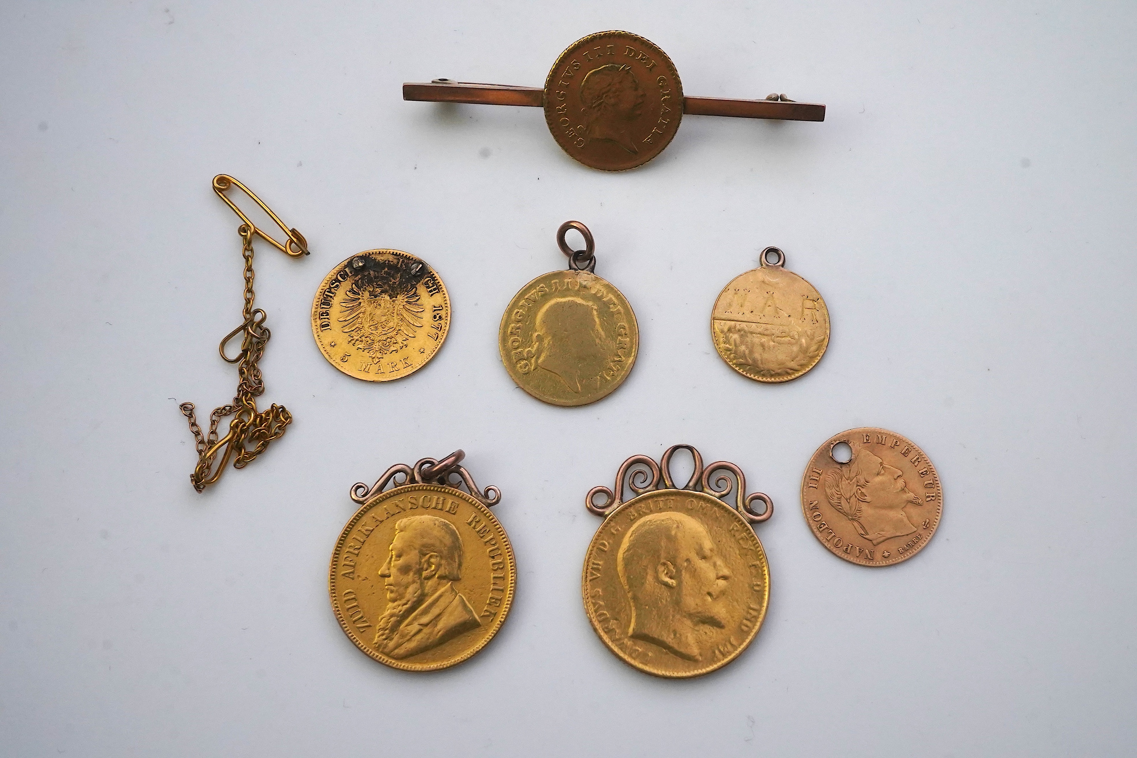 Seven assorted mounted or drilled gold coins